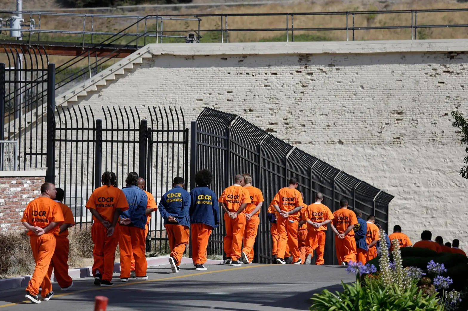 In this Aug. 16, 2016, file photo, general population inmates walk in a line at San Quentin State Prison in San Quentin, Calif. (AP Photo/Eric Risberg, File)